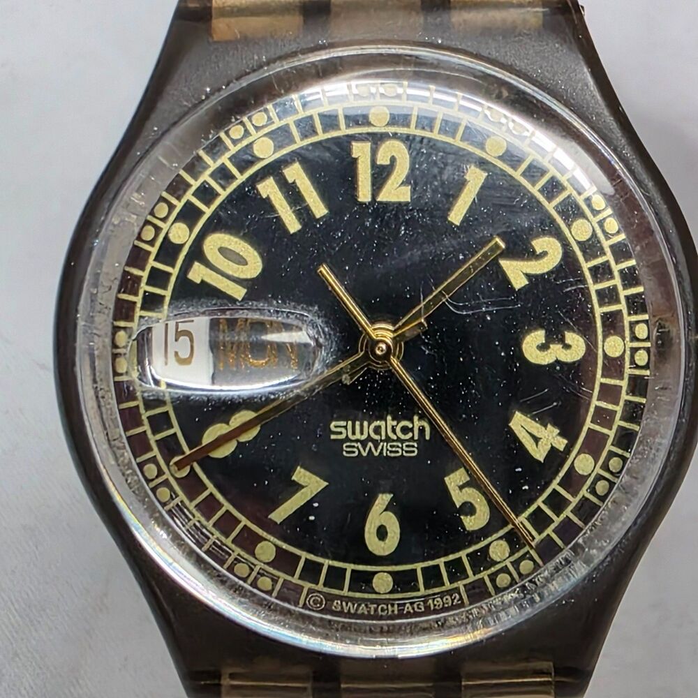 Swatch GM703 Sixtythree 33mm Unisex Watch Black Gold Dial Clear Band Swiss Made